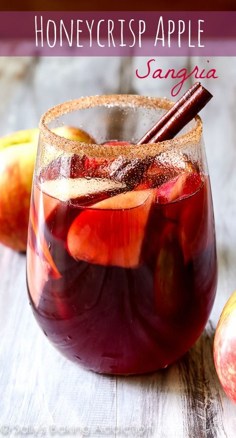 an apple sangria is served in a glass with cinnamon stick and sliced apples on the side