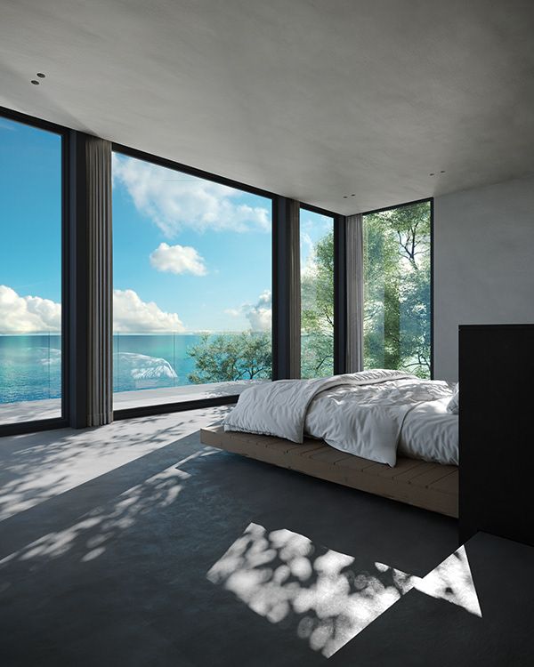 a bed sitting in the middle of a bedroom next to large windows with ocean view