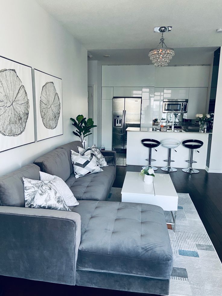 a living room filled with furniture next to a kitchen