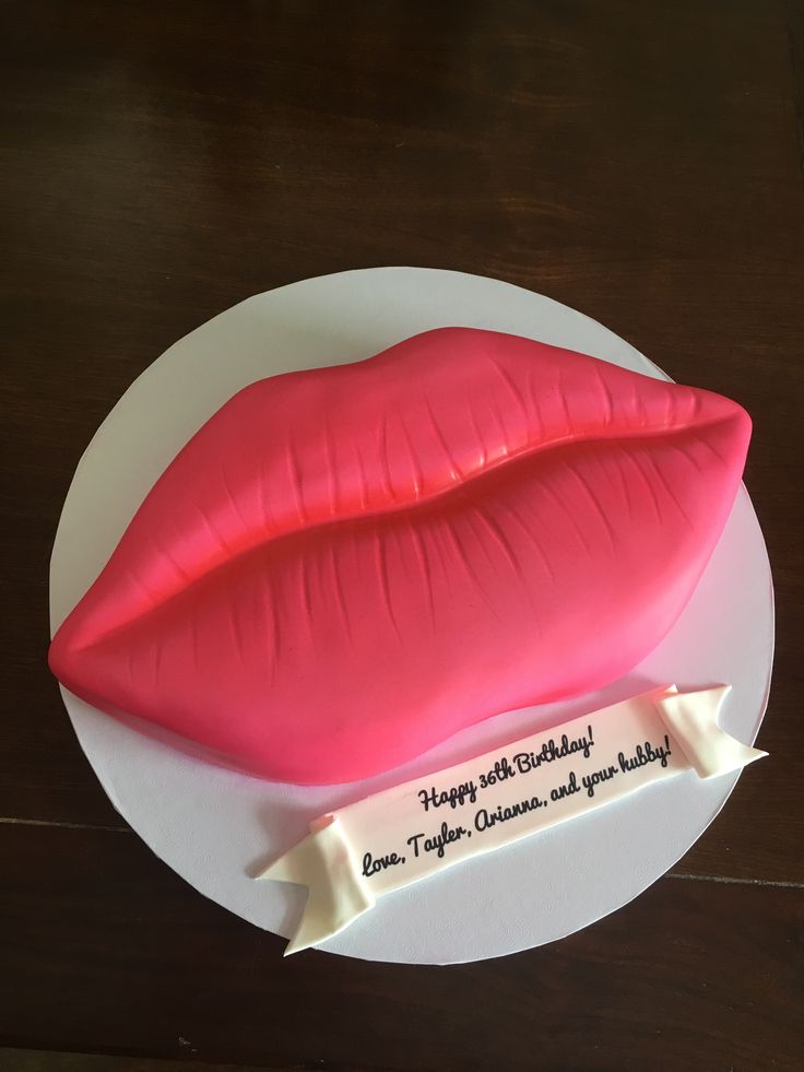 a cake shaped like a kiss on top of a white plate with the words happy birthday