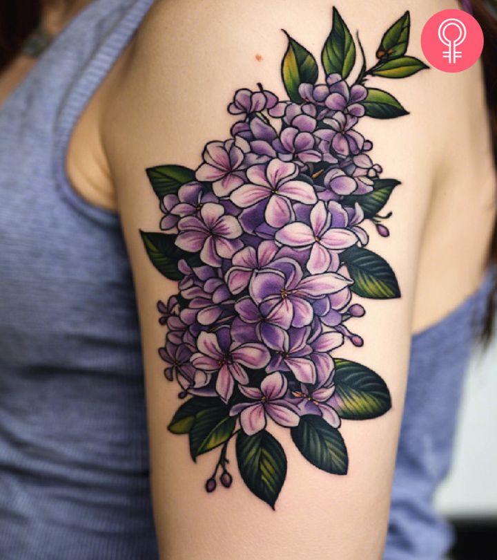 a woman's arm with purple flowers and green leaves on the left side of her arm