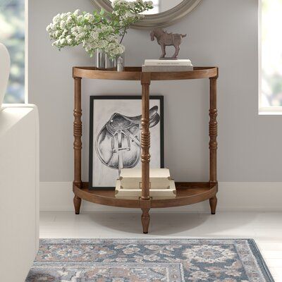 a round mirror sitting on top of a wooden shelf next to a white couch in a living room