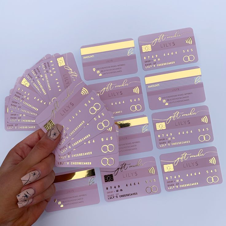 a person is holding up some purple stickers with gold foil on them and there are several different designs