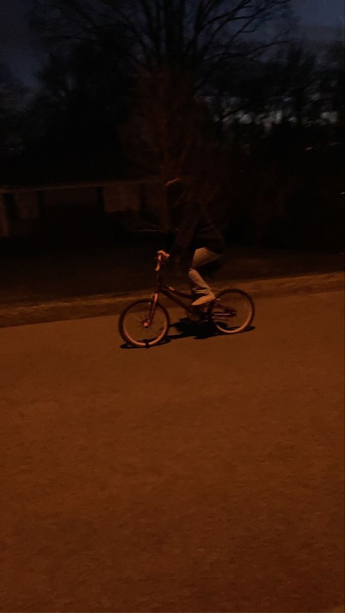 a person riding a bike in the dark