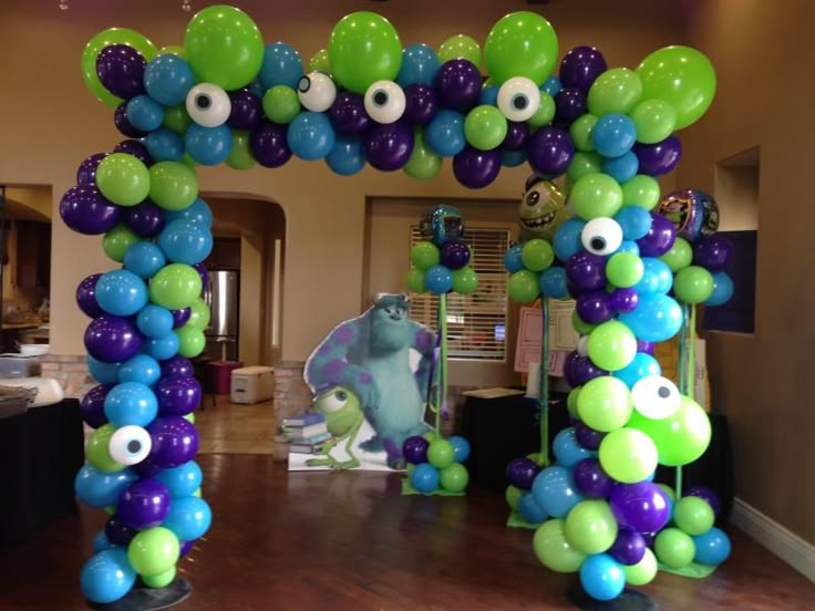 an arch made out of balloons with eyeballs on the front and back ends in blue, green, purple and white