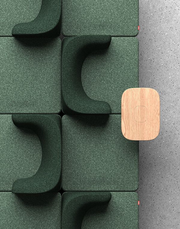 a wooden table sitting on top of a green chair next to a wall covered in foam