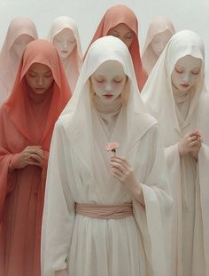 a group of women dressed in white standing next to each other with heads covered by veils