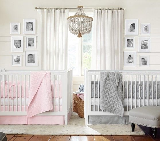 a baby's room with two cribs and pictures hanging on the wall