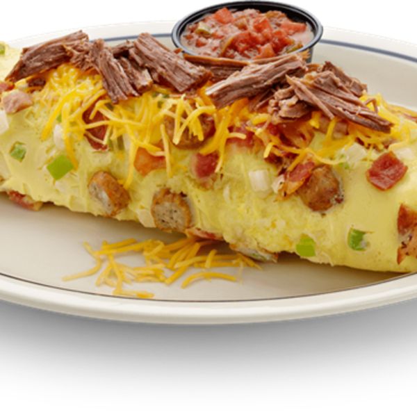 a white plate topped with an enchilada covered in meat and cheese