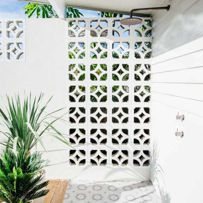 an outdoor shower area with plants and potted plants