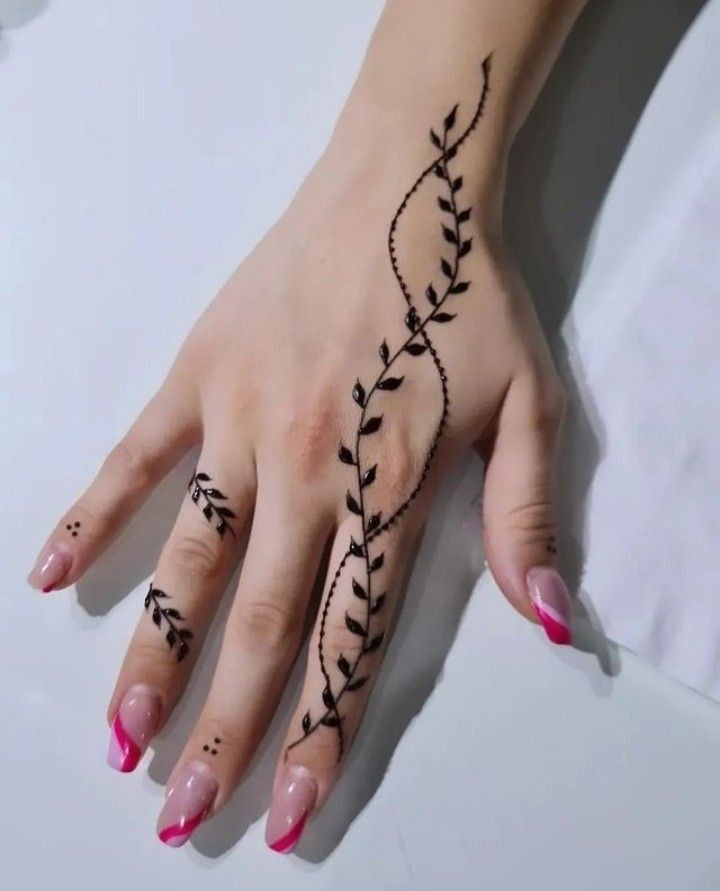 a woman's hand with a tattoo design on her left wrist and the other hand