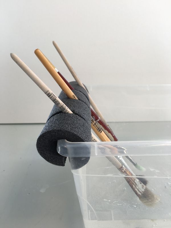 a plastic container filled with different types of knitting needles