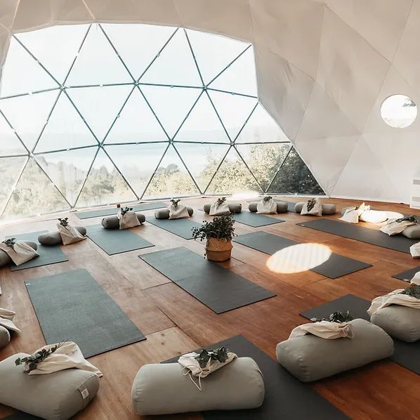 there are many yoga mats on the floor in front of a large window that overlooks mountains