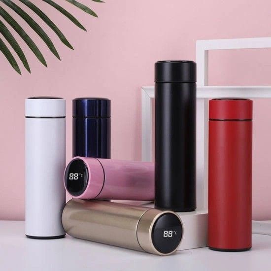 thermos are lined up next to each other in front of a pink wall