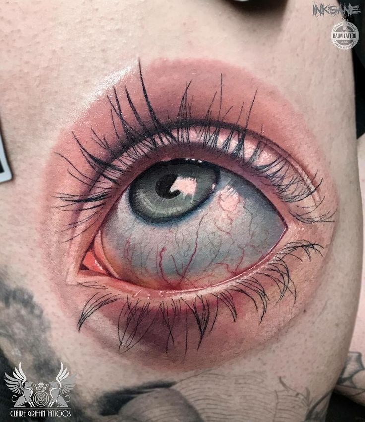 a close up of an eye with tattoos on it