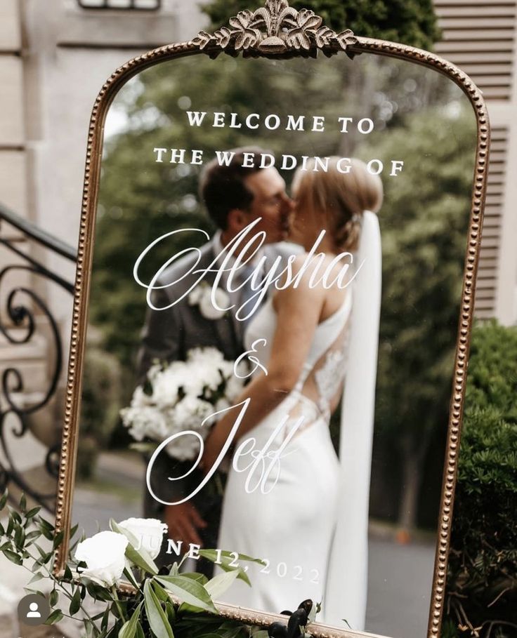 a couple kissing in front of a mirror with the words welcome to the wedding of alysna and jeff