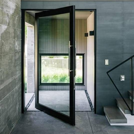 an open door leading into a room with concrete walls and stairs in front of it