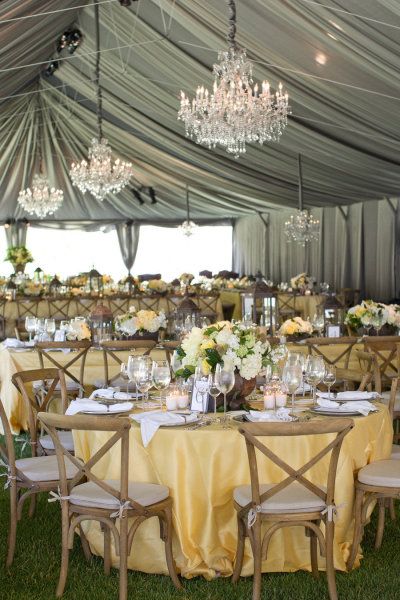 a large tent with tables and chairs covered in yellow cloths