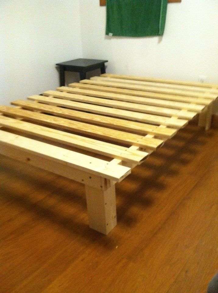 a wooden bed frame sitting on top of a hard wood floor