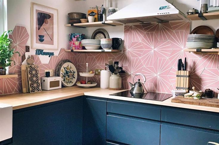 a kitchen with blue cabinets and pink wallpaper