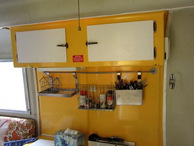 a kitchen with yellow cabinets and white cupboards