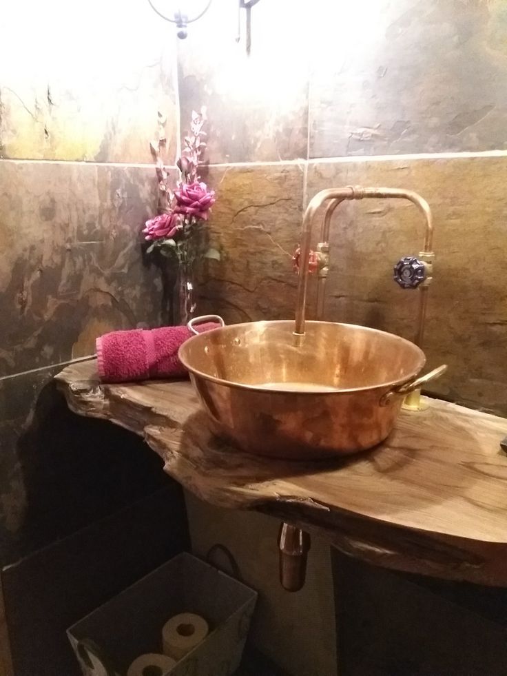 a large copper bowl sink in a bathroom