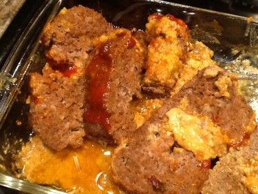 meatloaf with sauce and cheese in a pan on the stovetop, ready to be eaten