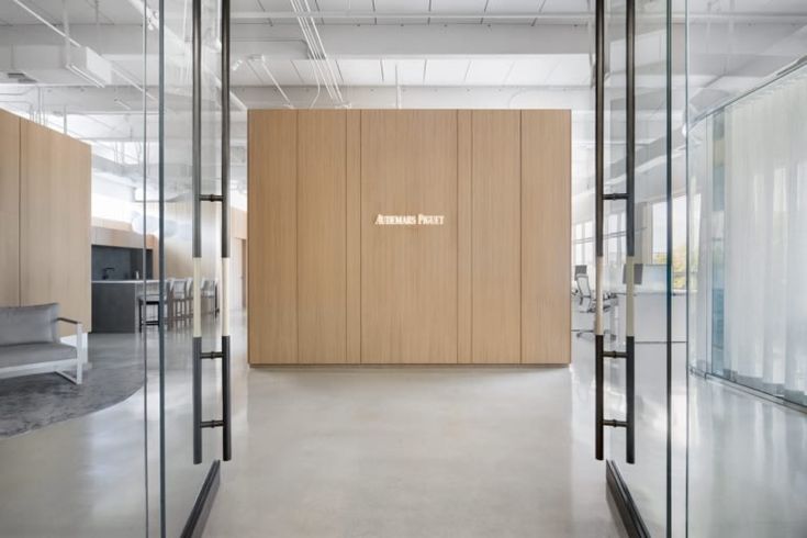 an empty office with glass walls and wood paneling