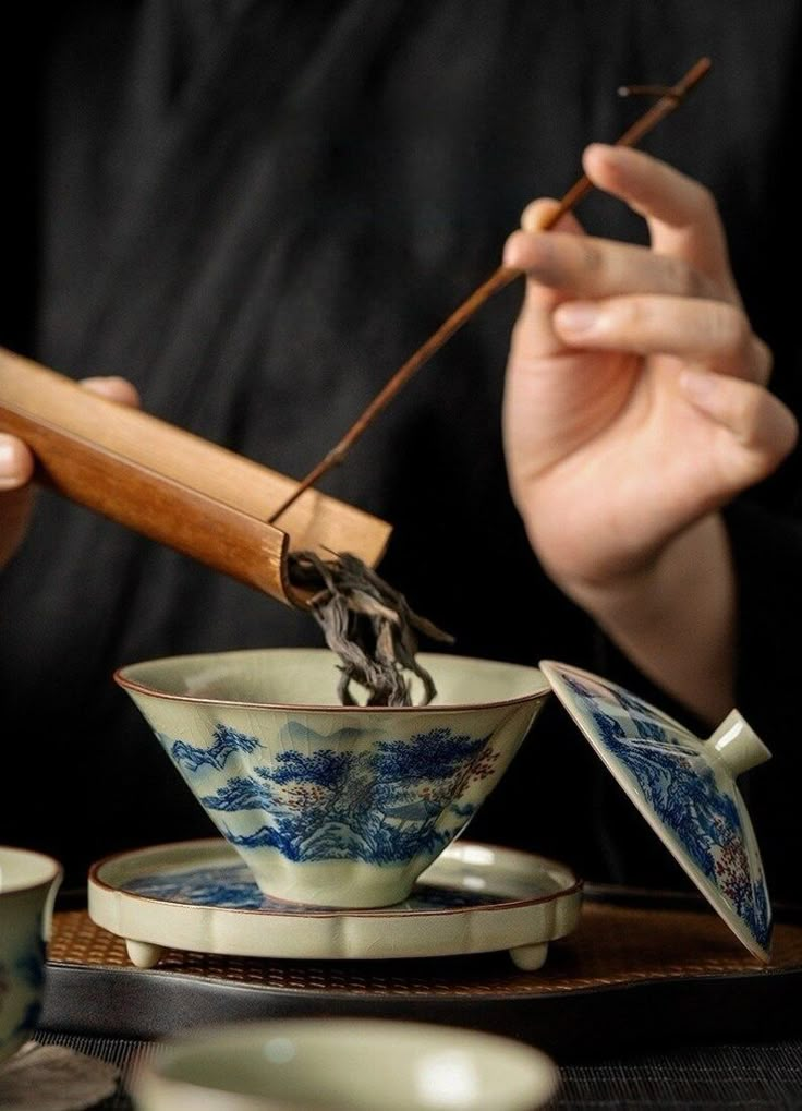 a person is holding chopsticks over a bowl