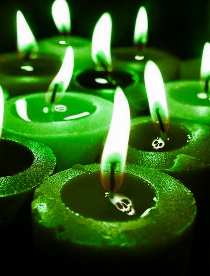 many green candles are lit in the dark