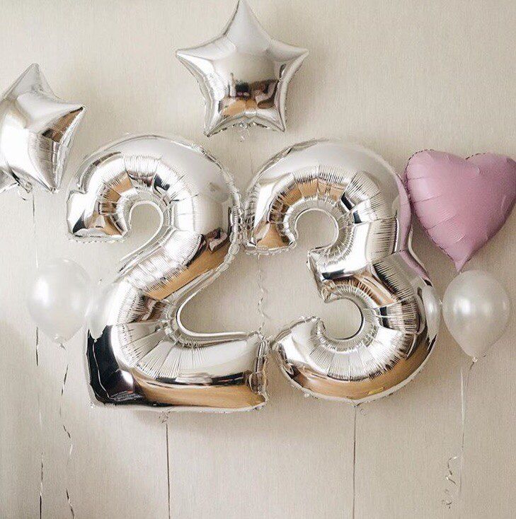 the number twenty two balloons are hanging on the wall next to some pink and white balloons