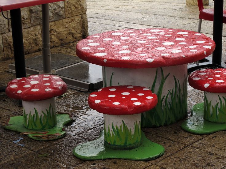 three red and white mushrooms sitting on top of each other in front of a table