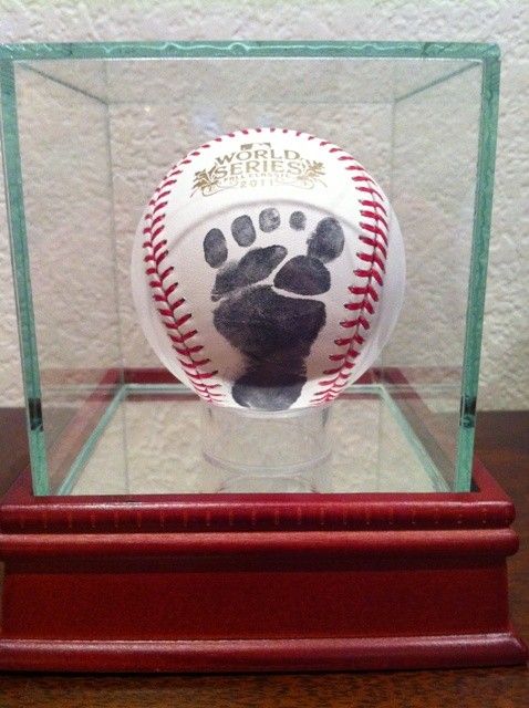 a baseball in a glass case with a hand print on the inside and bottom of it