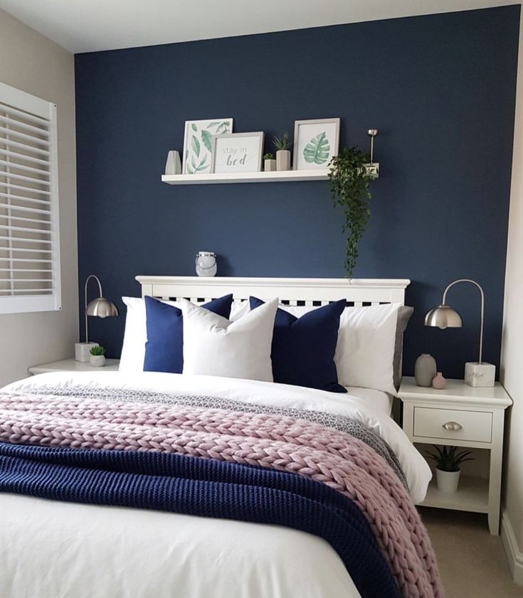 a bedroom with blue walls and white bedding