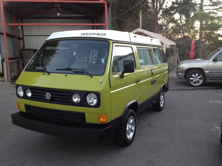 a small green van parked in a parking lot