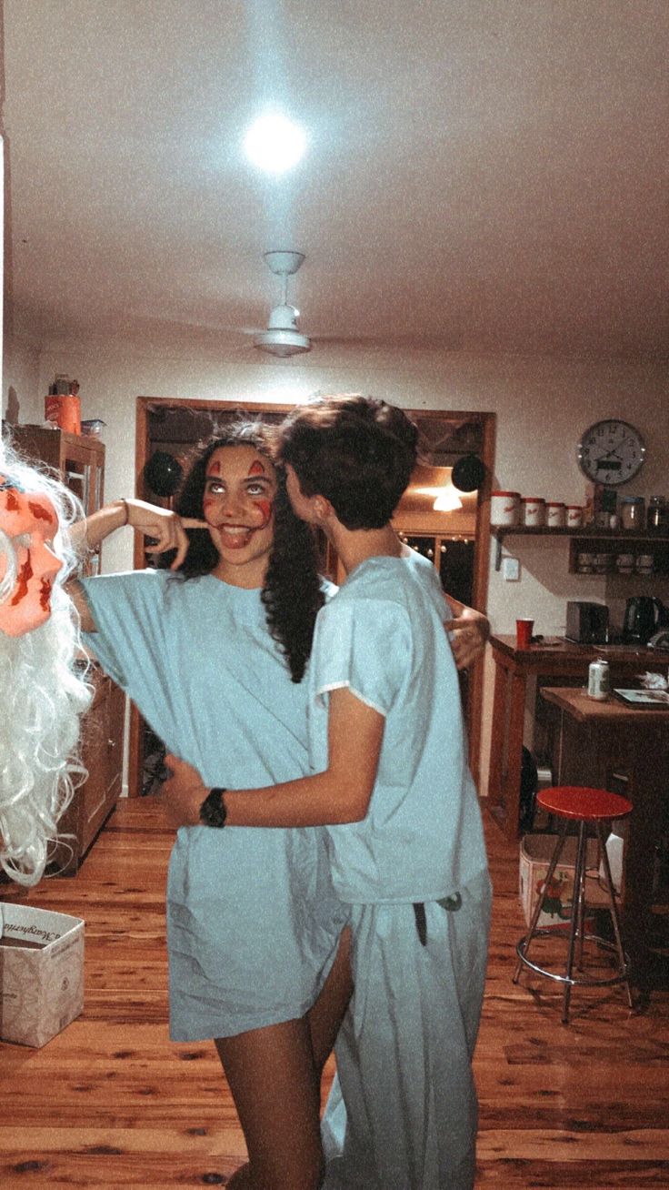 two women in scrubs standing next to each other on a hard wood flooring area