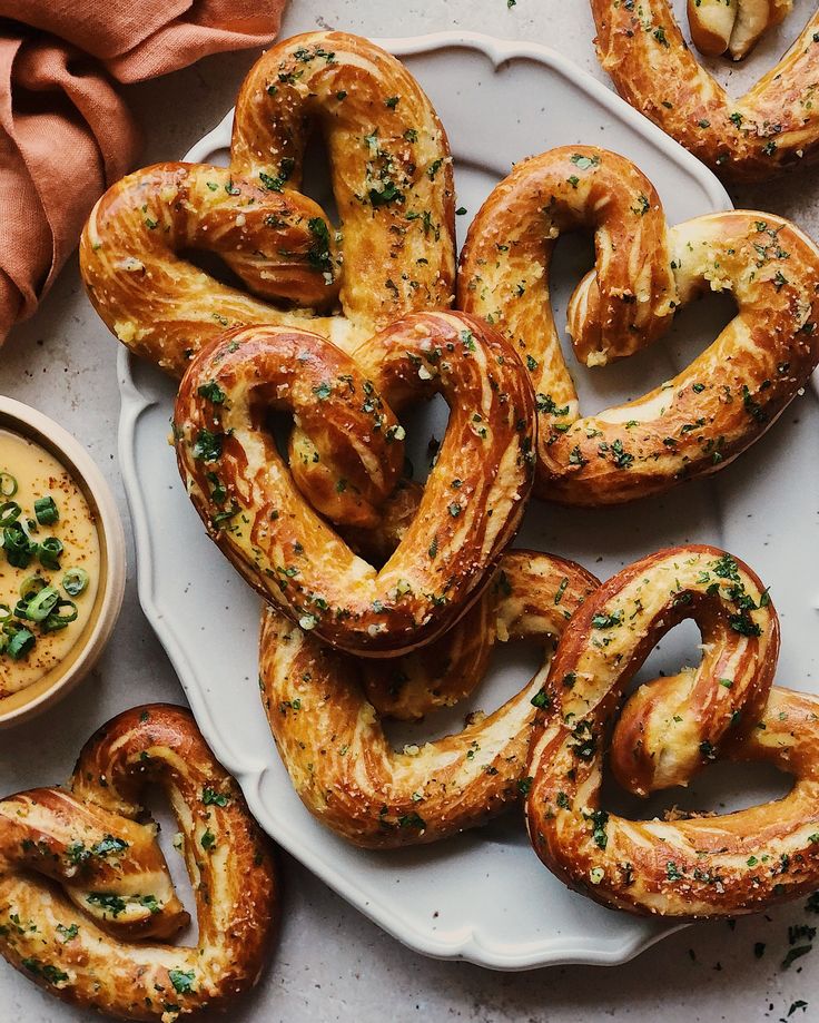 some pretzels are on a plate with dipping sauce