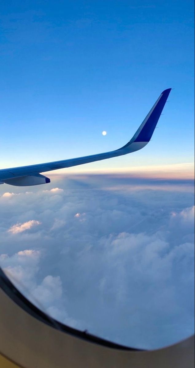 the wing of an airplane as it flies above the clouds in the blue and white sky