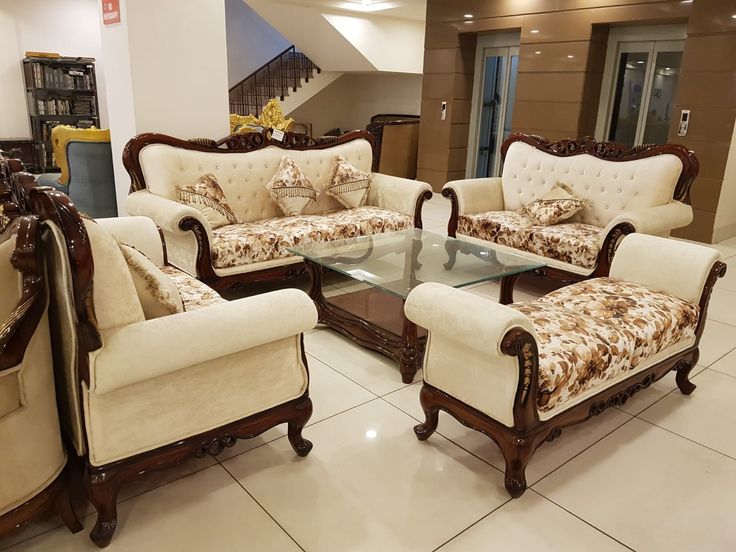 a living room with couches and chairs in it's center area, including a glass coffee table