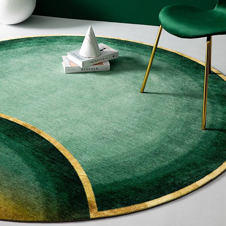 a round rug with green and gold designs on the floor next to a white chair