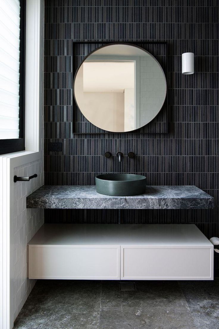 a bathroom sink with a mirror above it next to a shelf and cabinet under the counter