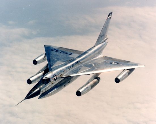 a silver fighter jet flying through the sky