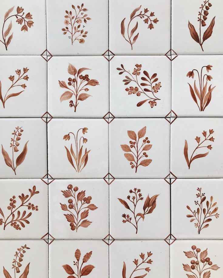 the tiles are decorated with different types of flowers and leaves in brown on white tile