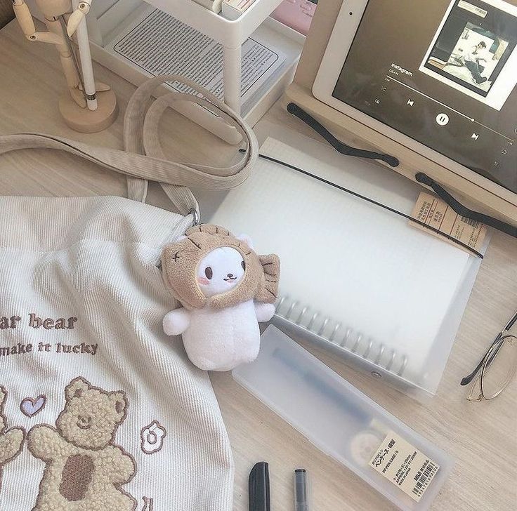 a stuffed animal sitting on top of a table next to a laptop computer and other items