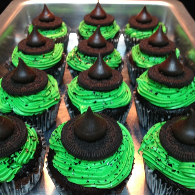 cupcakes with green frosting and chocolate tops on a metal tray, ready to be eaten