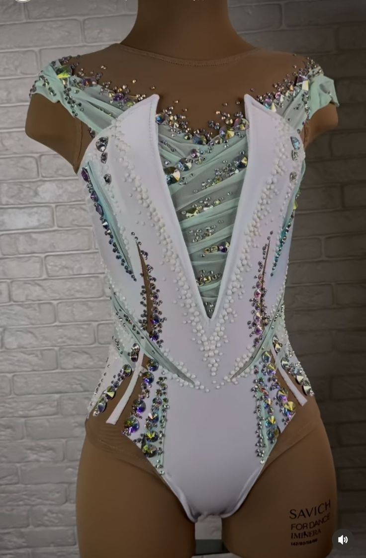 a woman's white leotard with sequins and beads on it