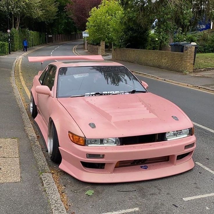 a pink car parked on the side of a road