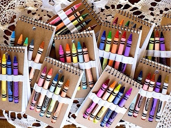 many different colored crayons in boxes on a doily