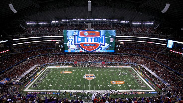 a stadium filled with lots of people watching a football game on the big screen tv