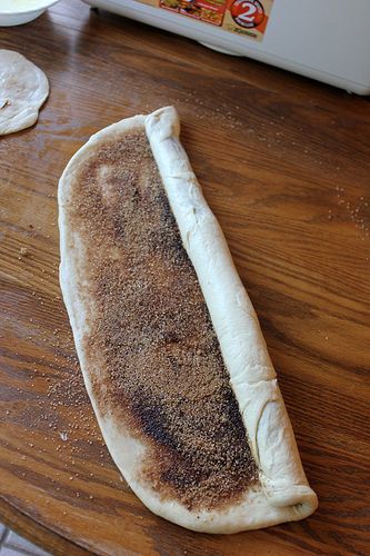 a long piece of bread sitting on top of a wooden table